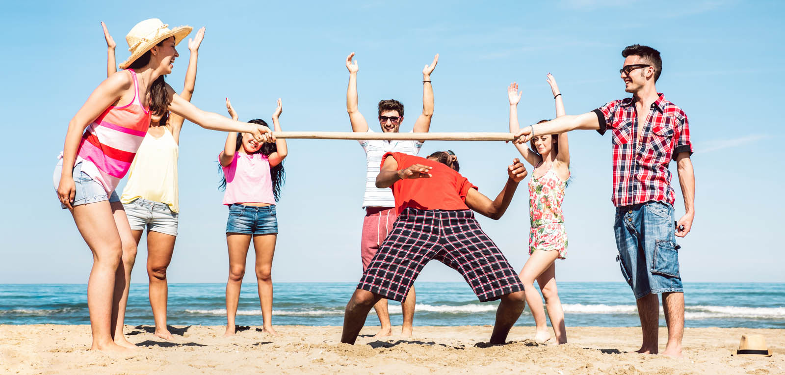 Multicultural friends group having fun together with limbo game